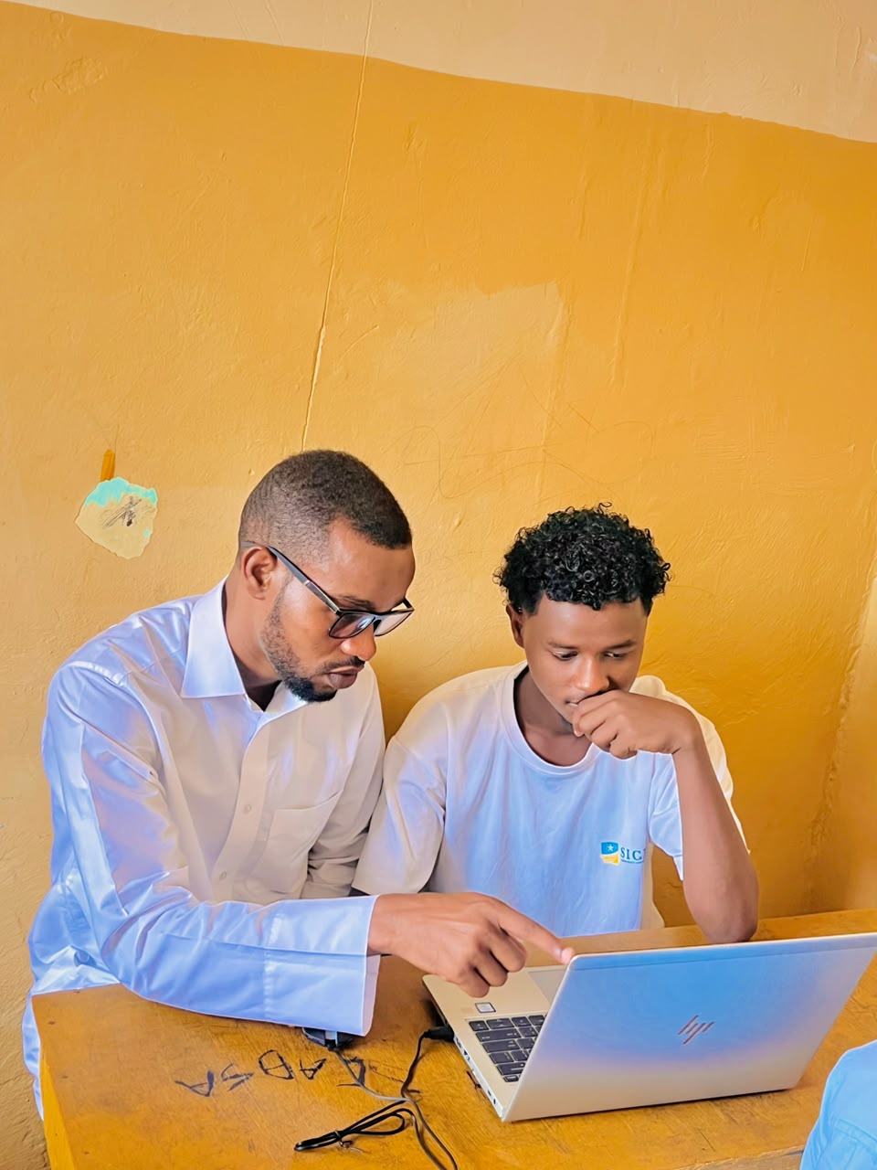 Instructor pointing at a laptop screen